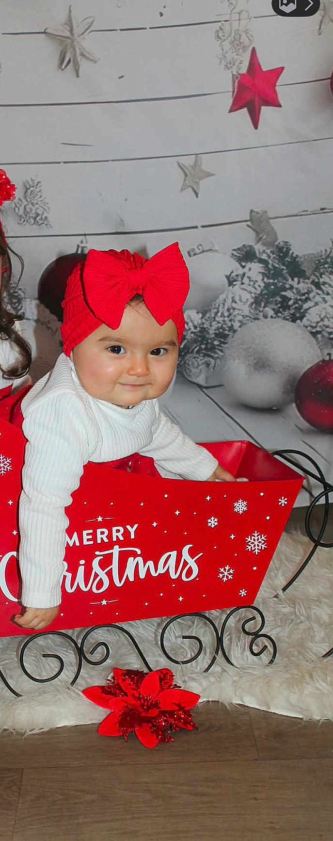 Leyna participe au concours pour gagner de l'argent avec cette photo : baby, child, red_bow, christmas, holiday, sleigh, decorations, ornaments, white_sweater, smiling, festive, indoor, floor, fur_rug, red, playful, cute, portrait, seasonal, celebration
