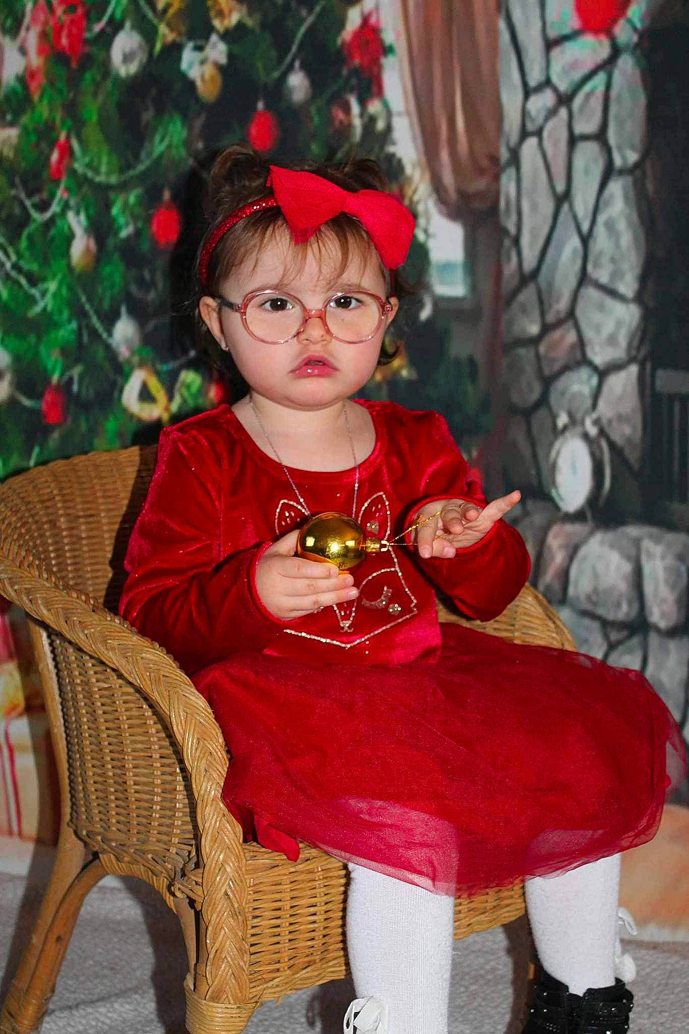 Illyana participe au concours pour gagner de l'argent avec cette photo : baby_toddler_clothing, child, christmas, christmas_decoration, christmas_ornament, christmas_tree, event, face, happy, head, holiday, outerwear, person, plant, red, sitting, sleeve, standing, toddler, tree