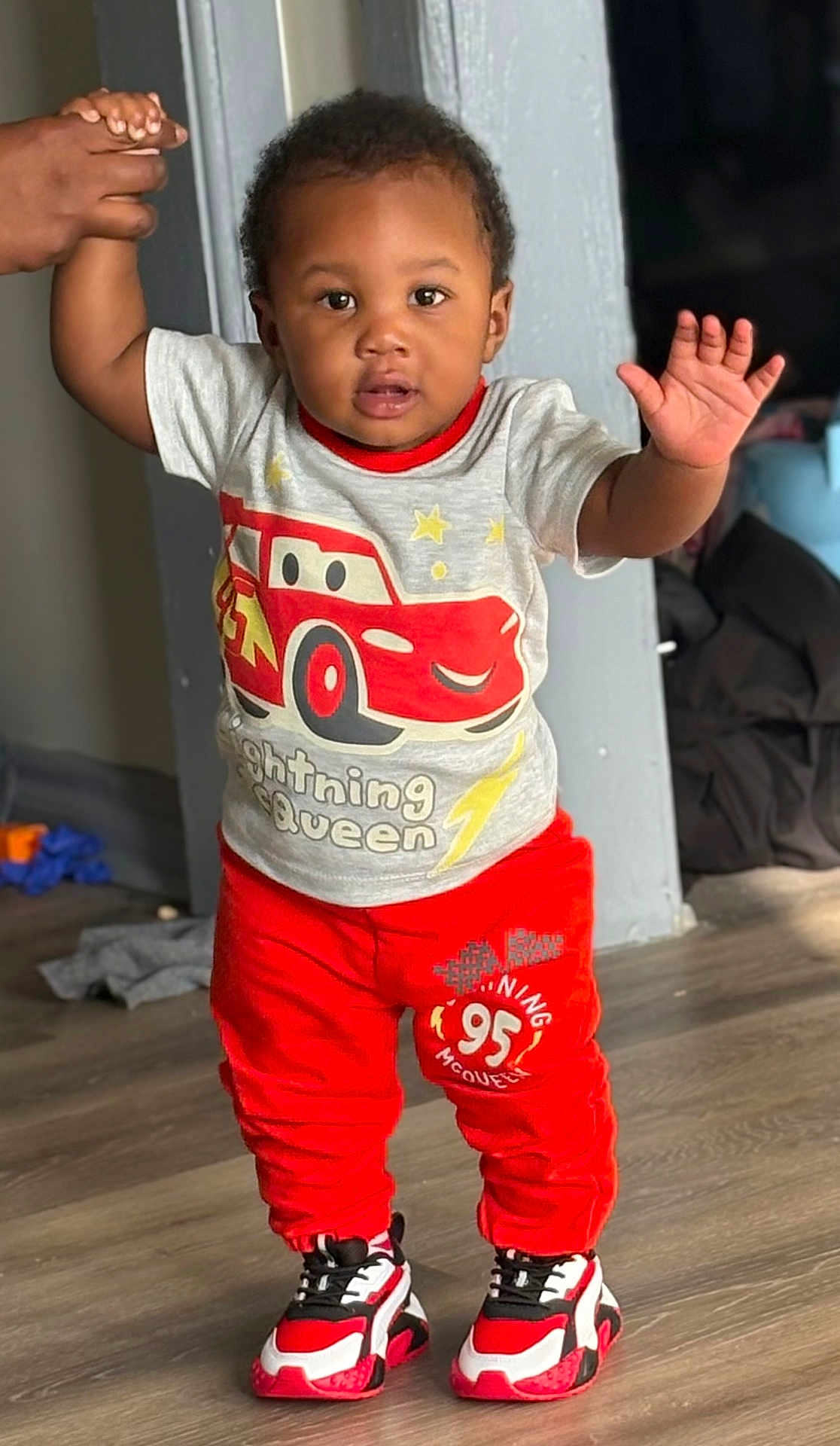Karzoo joined the competition — help win amazing prizes! casual, child, clothing, cute, face, floor, graphic_tshirt, hair, hand, holding_hand, home, indoor, lightning_mcqueen, person, red_pants, sneakers, standing, support, toddler, young_child