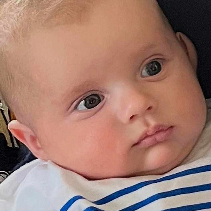 Aliocha participe au concours pour gagner de l'argent avec cette photo : baby, infant, child, striped_shirt, face, eyes, head, couch, cushion, clothing, soft_light, portrait, cute, indoors, expression, young, human, skin, hair, looking