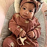 Nala is registered to the contest to win money with this photo: baby, infant, child, pacifier, headband, pink_clothing, bear_pattern, baby_seat, cushion, cozy, cute, indoor, portrait, hands, face, calm, curious, sitting, soft, clothing