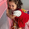 Nala is registered to the contest to win money with this photo: toddler, child, playpen, pink, red_dress, polka_dot_shirt, toys, book, mesh, curly_hair, indoor, barefoot, cute, standing, baby, play_area, colorful, mischievous, young_child, fun