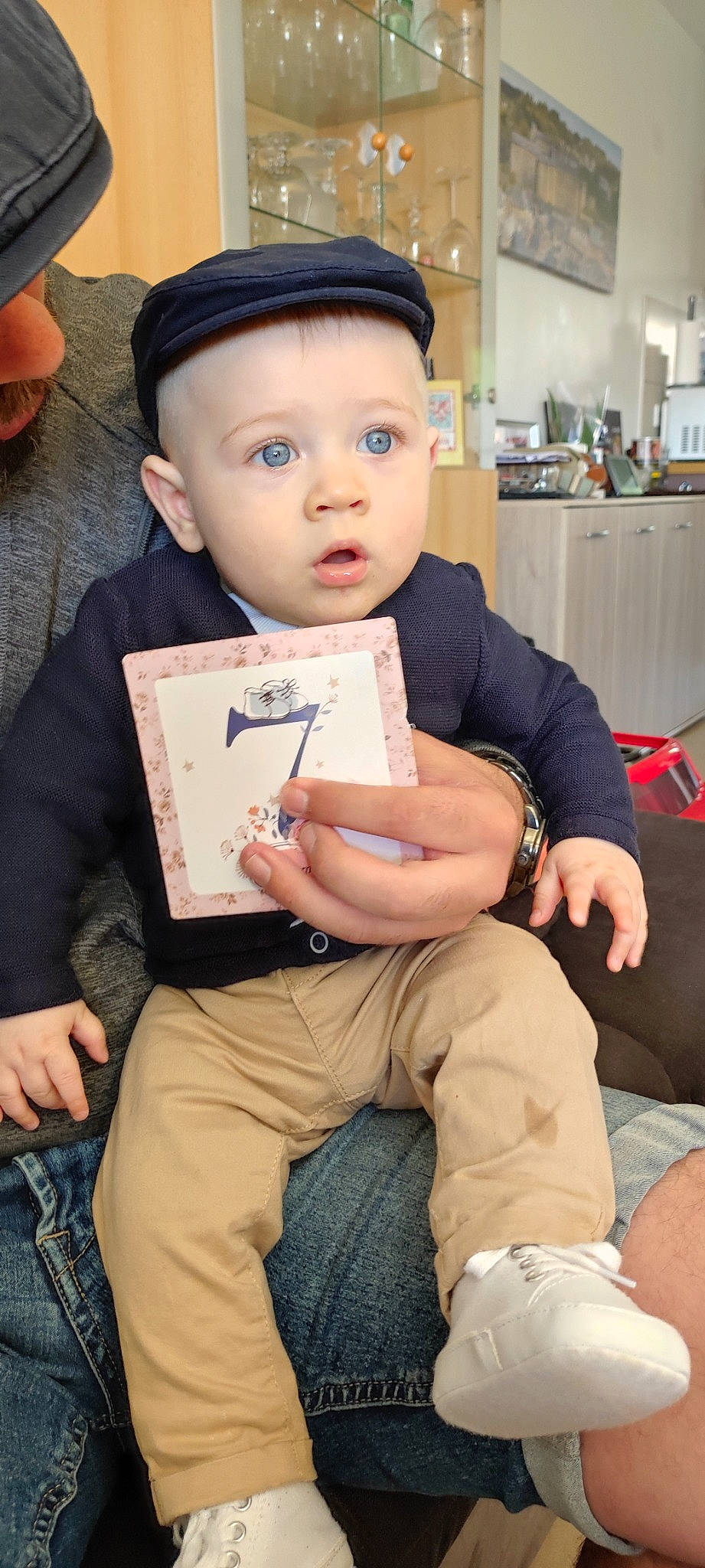 Elliott participe au concours pour gagner de l'argent avec cette photo : baby, cap, child, comfort, elbow, foot, hairstyle, hand, hat, human_leg, knee, lap, leg, person, reading, sitting, sock, surprise, thigh, toddler