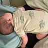 baby, infant, sleeping, onesie, animal_print, blanket, cushion, soft_fabric, indoor, resting, child, person, head, arm, leg, skin, home, comfort, peaceful, nap