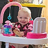 baby, smile, walker, toy, bottle, indoor, child, clothing, face, pink, plastic, furniture, happy, person, seat, play, young_child, cute, expression, home
