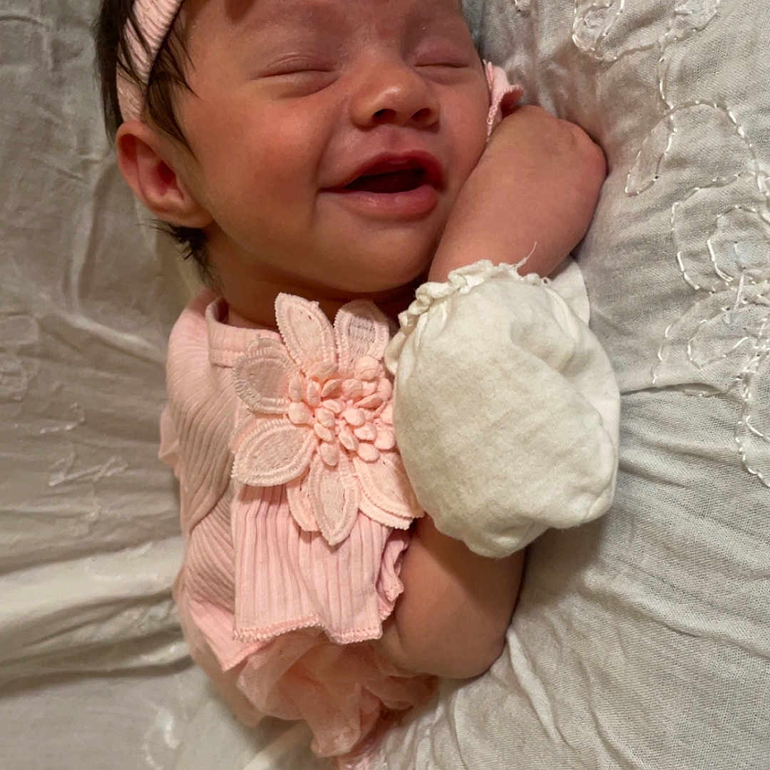 Xiomarrah joined the competition — help win amazing prizes! baby, child, closeup, cushion, cute, face, flower, hand, headband, indoors, infant, newborn, peaceful, pink_clothing, portrait, resting, sleeping, smiling, soft_texture, white_fabric