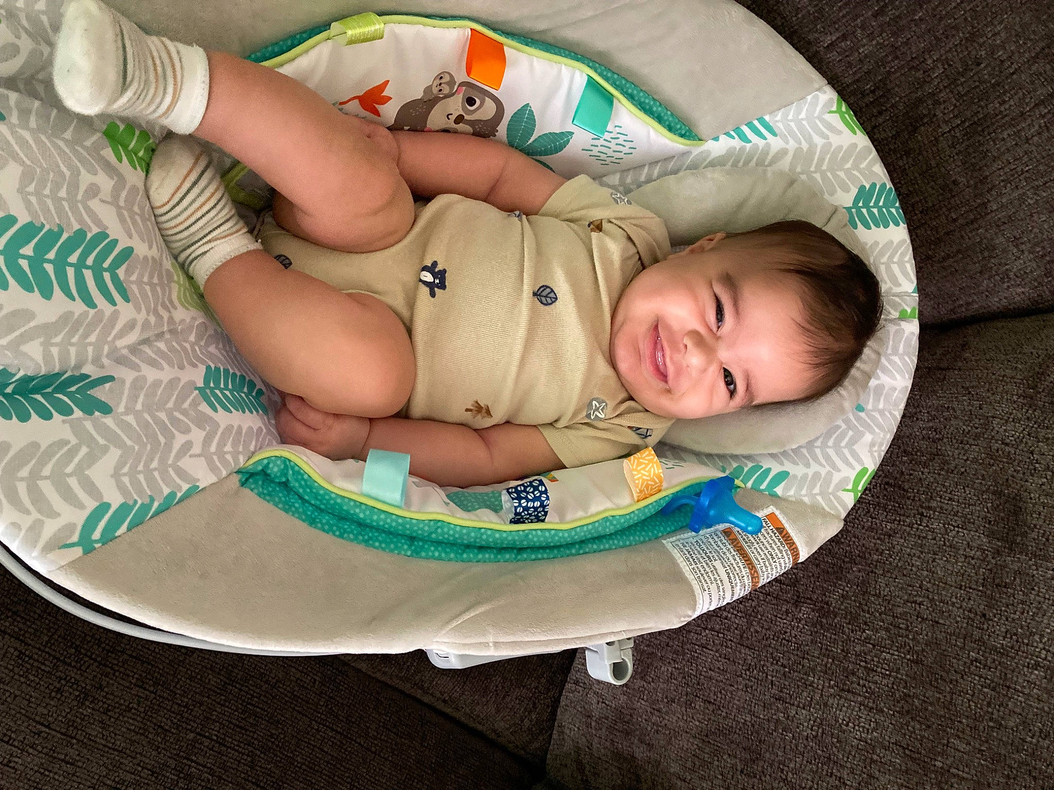 Vicente is registered to the contest to win money with this photo: arm, baby, baby_carriage, baby_products, baby_toddler_clothing, bedtime, comfort, elbow, grass, hand, head, human_leg, joy, lap, linens, pattern, person, sitting, smile, thigh