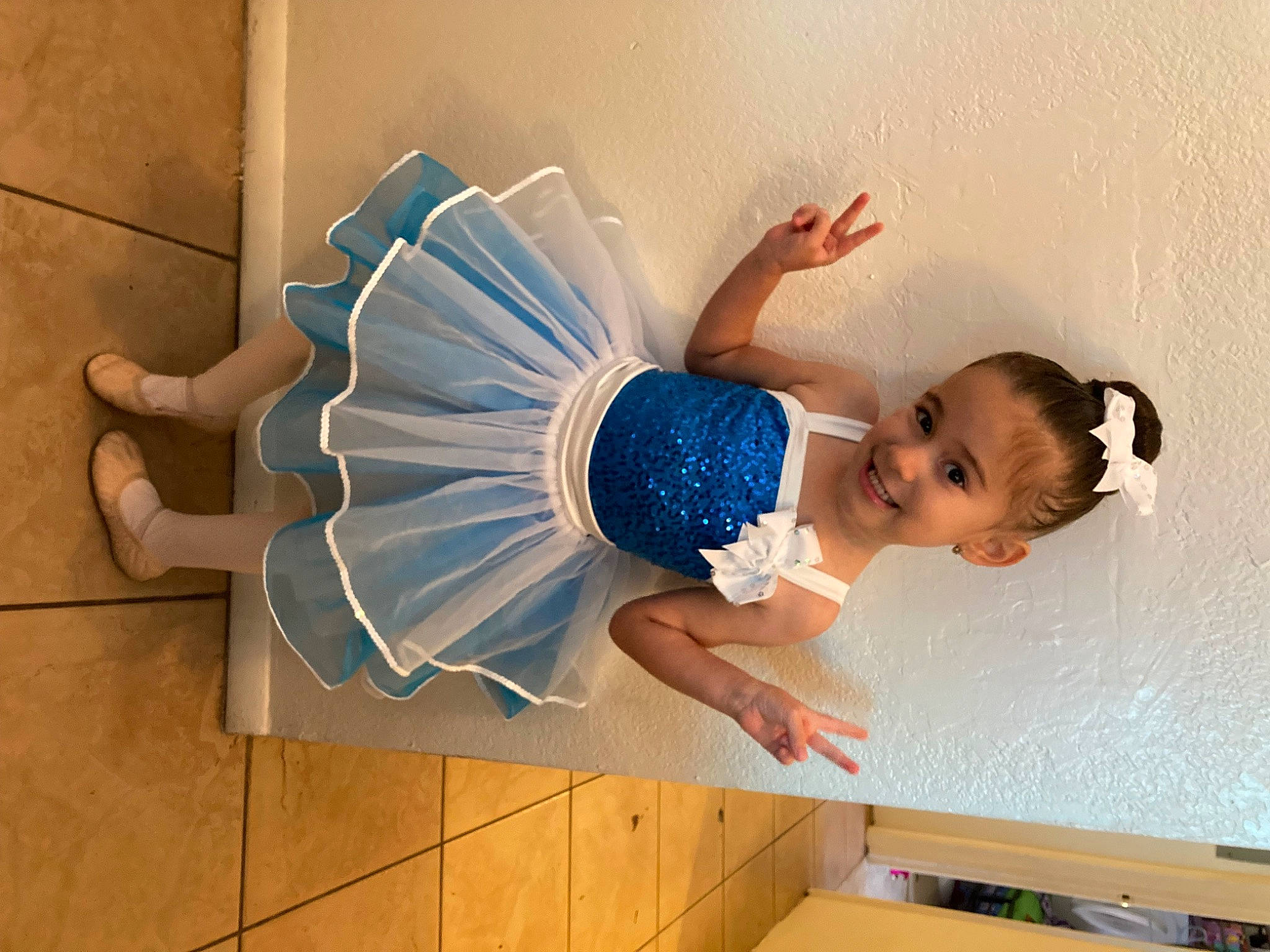 Emma is registered to the contest to win money with this photo: abdomen, baby, baby_toddler_clothing, child, elbow, electric_blue, flooring, fun, happy, hardwood, human_leg, joy, knee, leisure, pattern, person, room, sitting, thigh, toddler