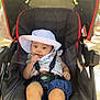 accessories, baby, baseballcap, bonnet, cap, clothing, electronics, face, hat, head, outdoors, pants, person, photography, portrait, shorts, strap, stroller, sunglasses, sunhat