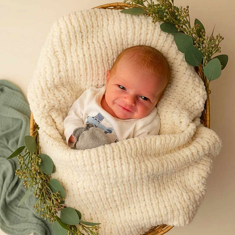 Colson joined the competition — help win amazing prizes! baby, newborn, blanket, basket, greenery, smile, cute, portrait, soft_texture, infant, wrapped, cozy, adorable, child, laying, indoors, warm, natural_light, peaceful, toddler