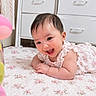 Aurora is registered to the contest to win money with this photo: baby, infant, child, smiling, laughing, portrait, indoors, bedroom, bed, floral_bedding, pink_dress, lace, balloons, white_drawers, furniture, dark_hair, lying_down, happy, face, photography