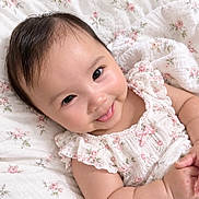 Aurora joined the competition — help win amazing prizes! baby, child, infant, smiling, happy, portrait, face, eyes, floral, dress, ruffles, bow, bed, bedspread, bedding, indoors, lying_down, close_up, cute, photography