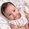 baby, child, infant, smiling, happy, portrait, face, eyes, floral, dress, ruffles, bow, bed, bedspread, bedding, indoors, lying_down, close_up, cute, photography