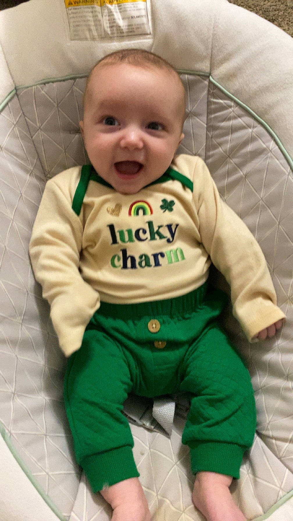 Noah is registered to the contest to win money with this photo: arm, baby, baby_safety, baby_toddler_clothing, cheek, child, comfort, eye, face, facial_expression, green, hand, happy, head, human_body, person, skin, sleeve, smile, t_shirt