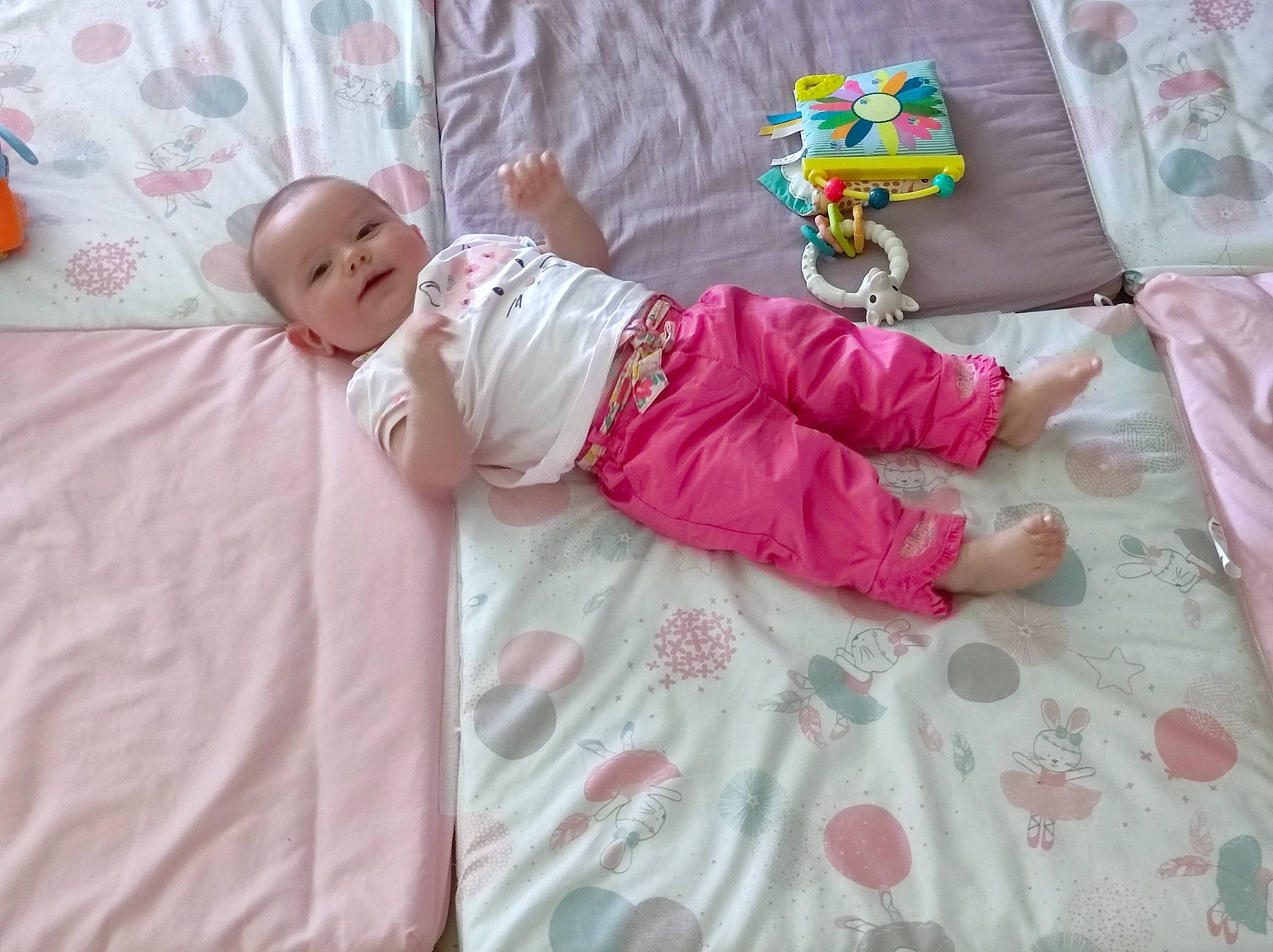 Aimée a rejoint le concours — aidez-le/la à gagner de superbes lots ! baby, baby_products, baby_toddler_clothing, bed_sheet, bedding, child, comfort, flooring, foot, linens, magenta, pattern, person, pink, product, room, sitting, sleeve, sock, textile