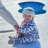 baby, child, snow, winter, outdoor, cold, knit_hat, onesie, smile, blue_pool, sunlight, holding_hand, sitting, grass, shadow, warm_clothing, happy, person, playing, daytime