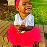 Dawn is registered to the contest to win money with this photo: toddler, child, smiling, headband, pink_tutu, white_shirt, clapping_hands, outdoor, brick_wall, grass, sunlight, happy, cute, baby_shoes, sock, person, portrait, young_child, playful, daytime