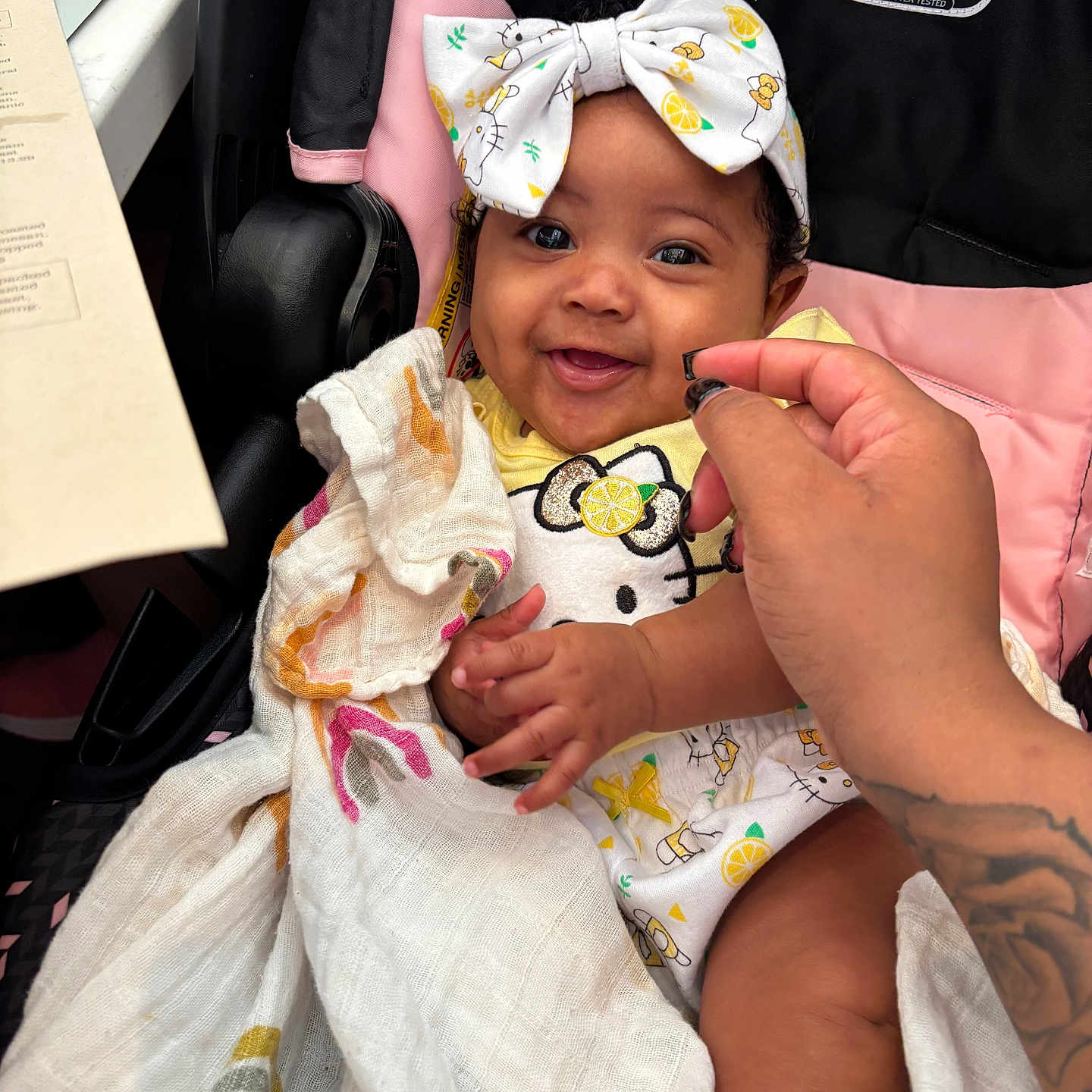 Jamaya is registered to the contest to win money with this photo: baby, black, blanket, bow, child, clothing, cute, fabric, hand, happy, headband, hello_kitty, indoors, infant, pattern, person, pink, smiling, stroller, tattoo