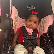 Jamaya joined the competition — help win amazing prizes! baby, car_seat, child, infant, red_bow, pink, black, white_pants, safety_harness, seat_belt, evenflo, indoor, cute, portrait, child_seat, young_child, face, person, clothing, sitting