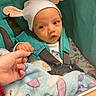 baby, child, infant, hat, ears, stroller, blanket, hand, finger, clothing, teal, cute, cozy, patterned, soft, person, portrait, indoors, seatbelt, holding