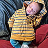 baby, sleeping, hoodie, yellow, blue_stripes, infant, child, cozy, fabric, blanket, clothing, rest, peaceful, cute, portrait, person, indoor, soft, casual, relaxation
