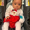 adorable, baby, car_seat, child, curious, cute, face, holiday_outfit, indoor, infant, pacifier, person, pink_clothing, portrait, red_skirt, santa_clothing, seated, tights, white_bows, young_child