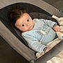 baby, baby_boy, baby_rocker, blanket, blue_clothing, casual, child, comfortable, curious_look, dark_hair, floor, home, indoor, infant, light_blue, person, portrait, seated, soft_toy, young_child