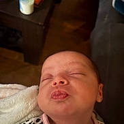 Blakeley joined the competition — help win amazing prizes! baby, infant, face, closed_eyes, puckered_lips, blanket, leopard_print, clothing, indoor, couch, table, bottle, wood_floor, sleeping, cute, child, person, skin, head, portrait