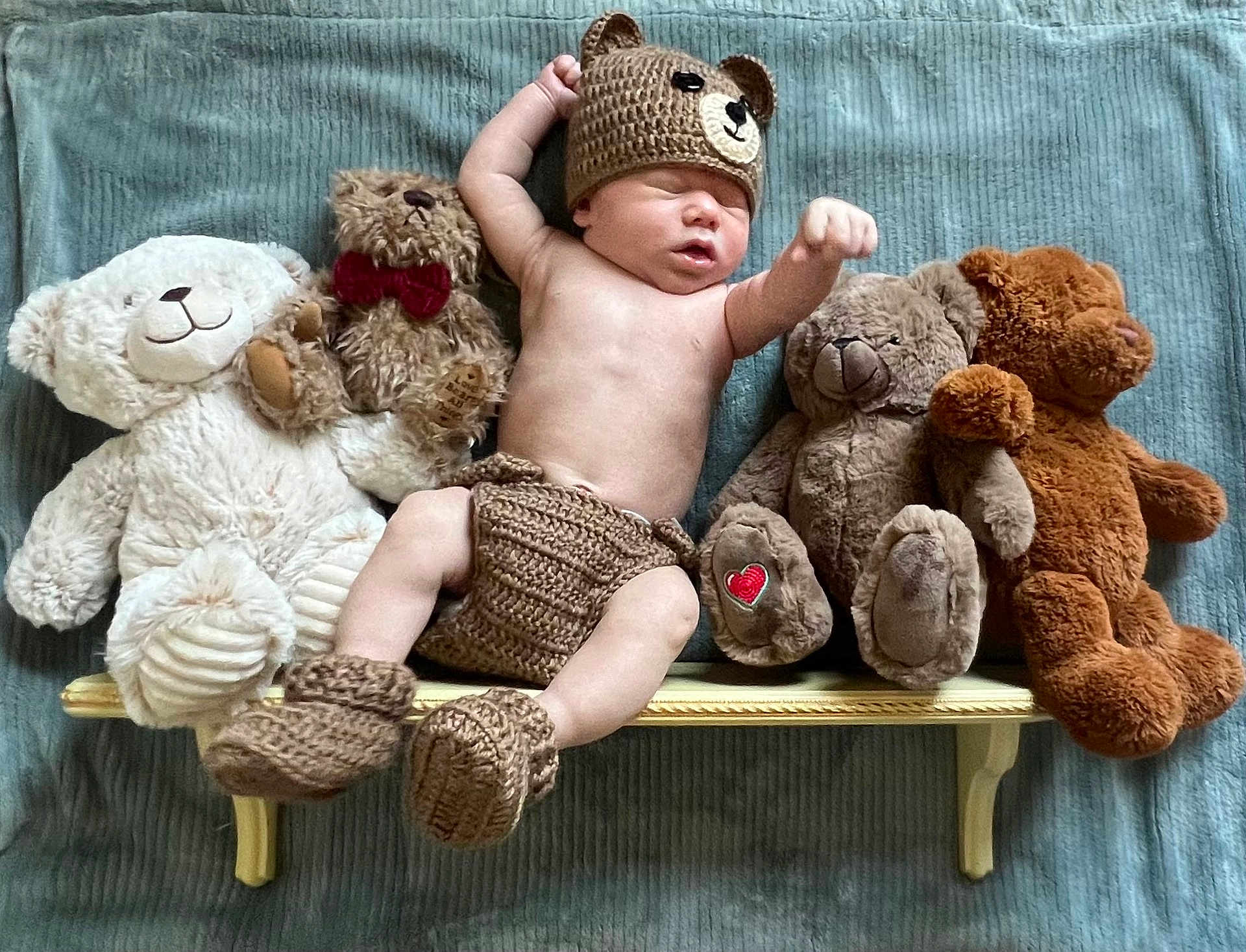 Coltlon is registered to the contest to win money with this photo: baby, sleeping, knitted_clothing, bear_hat, bear_booties, plush_toys, teddy_bears, bench, blanket, soft_toys, infant, cute, resting, child, cozy, indoor, portrait, toy_collection, nursery, peaceful