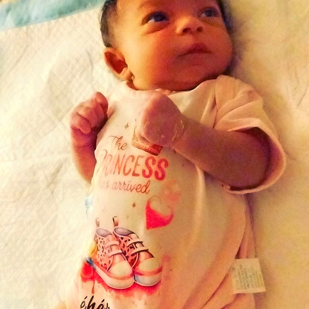 Shéhérazade a rejoint le concours — aidez-le/la à gagner de superbes lots ! baby, bed, blanket, cute, decorative, eyes, face, fingers, hands, indoor, infant, lying_down, mattress, newborn, onesie, pattern, pink, portrait, sheet, textile