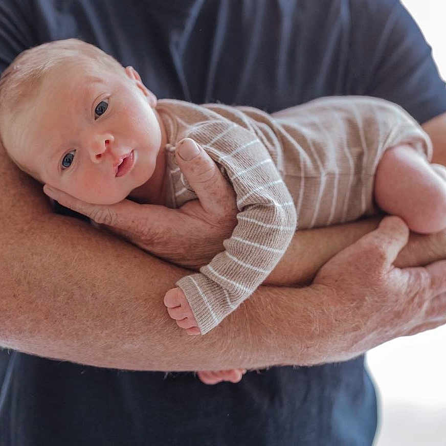 Angus joined the competition — help win amazing prizes! arms, baby, caring, closeup, clothing, cute, eyes, face, hands, holding, human, indoor, infant, newborn, parent, person, portrait, skin, soft_light, striped_onesie