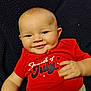 Daryl joined the competition — help win amazing prizes! baby, infant, smile, red_shirt, fourth_of_july, hand, face, blue_eyes, blanket, cute, child, happy, lying_down, skin, young, portrait, casual_clothing, indoors, expression, cheerful