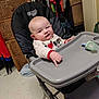 baby, high_chair, pointing, indoor, child, clothing, face, person, furniture, pacifier, expression, hand, floor, room, drawer, cabinet, toy, sleeve, footwear, looking
