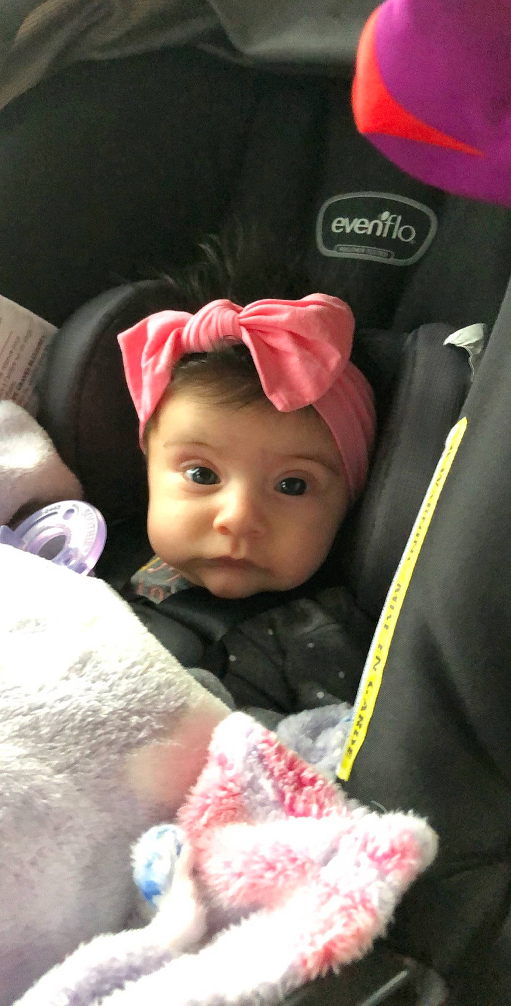Sailor is registered to the contest to win money with this photo: baby, car_seat, cheek, child, ear, hair_accessory, headgear, person, pink, toddler