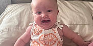 Oaklee Mae joined the competition — help win amazing prizes! baby, infant, smiling, sitting, romper, orange_pattern, couch, indoor, wooden_wall, cute, child, happy, skin, person, clothing, cute_outfit, fun, portrait, young_child, comfortable