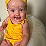 baby, child, smile, yellow_clothing, headband, cute, sitting, infant, happy, portrait, soft_texture, cushion, indoor, closeup, skin, face, eyes, expression, person, young