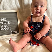 Oaklee Mae joined the competition — help win amazing prizes! baby, infant, child, sitting, blanket, letter_board, text, clothing, navy_blue, red, white, skin, foot, hand, face, expression, cute, indoors, soft, portrait