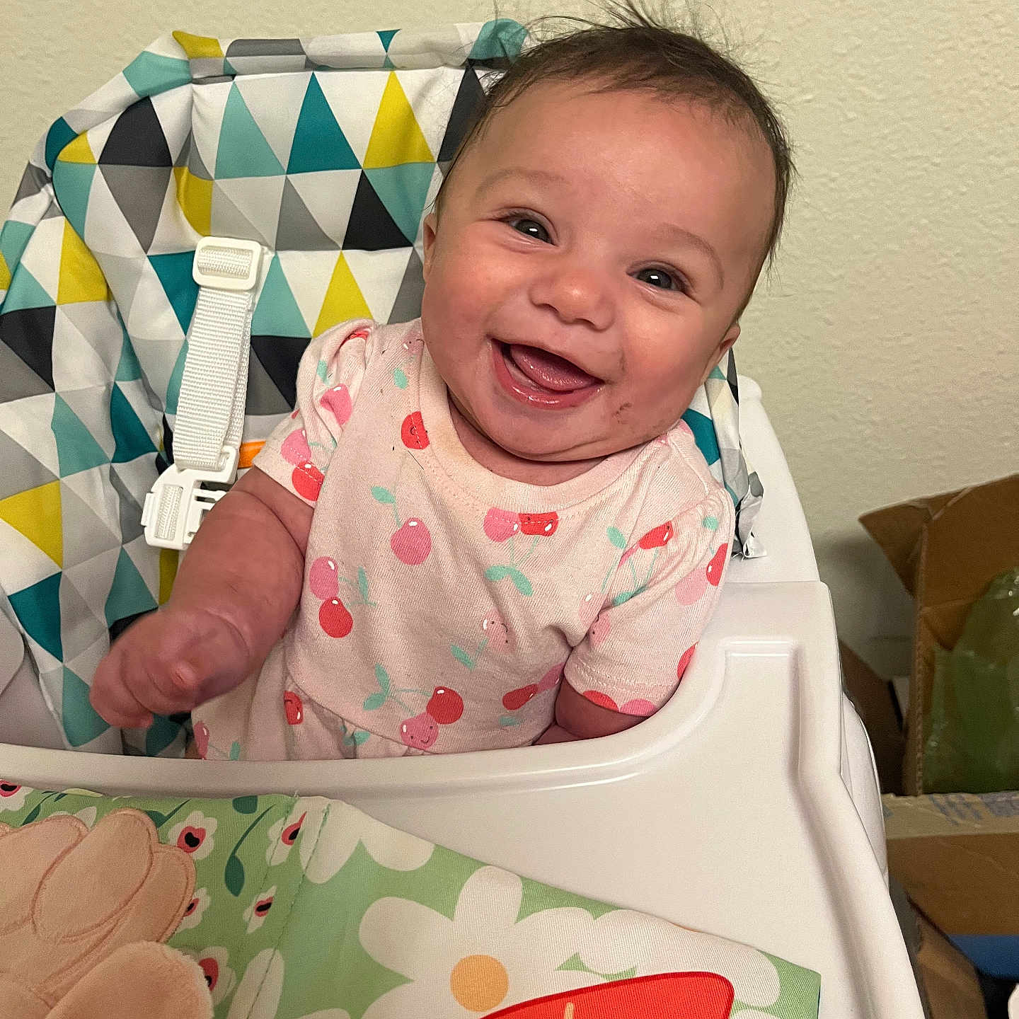 Tianna joined the competition — help win amazing prizes! baby, cheerful, child, clothing, colorful, cute, face, fun, happy, high_chair, home, indoor, infant, patterned_fabric, person, portrait, seat_belt, smiling, toddler, young_child