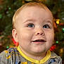 baby, child, face, smile, eyes, blond_hair, pajamas, construction_theme, closeup, portrait, indoors, holiday, christmas_tree, decorations, blurred_background, cute, happy, infant, young_child, cheerful