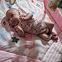 baby, child, colorful, cute, decor, expression, face, footwear, hand, indoor, infant, lying_down, onesie, patterned, pink, playmat, playtime, socks, soft_toys, toy