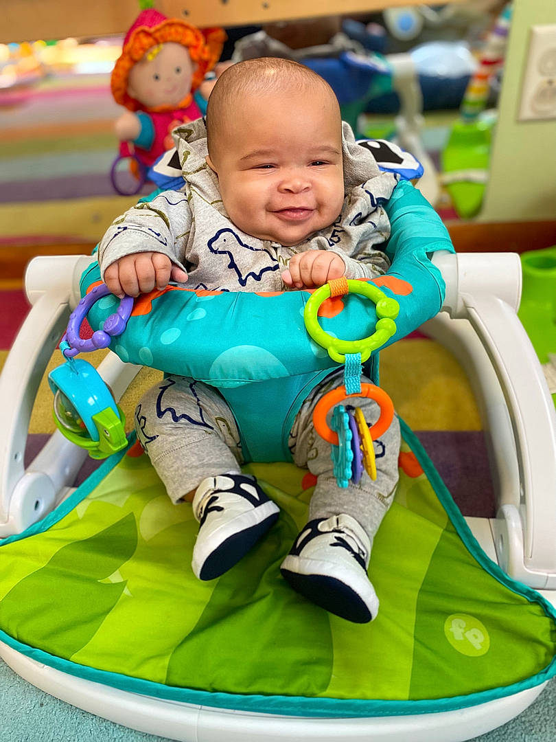 Kashton is registered to the contest to win money with this photo: baby, baby_playing_with_toys, baby_toddler_clothing, child, comfort, event, fun, green, happy, leisure, mammal, person, playing_with_kids, product, sitting, skin, smile, snapshot, toddler, white