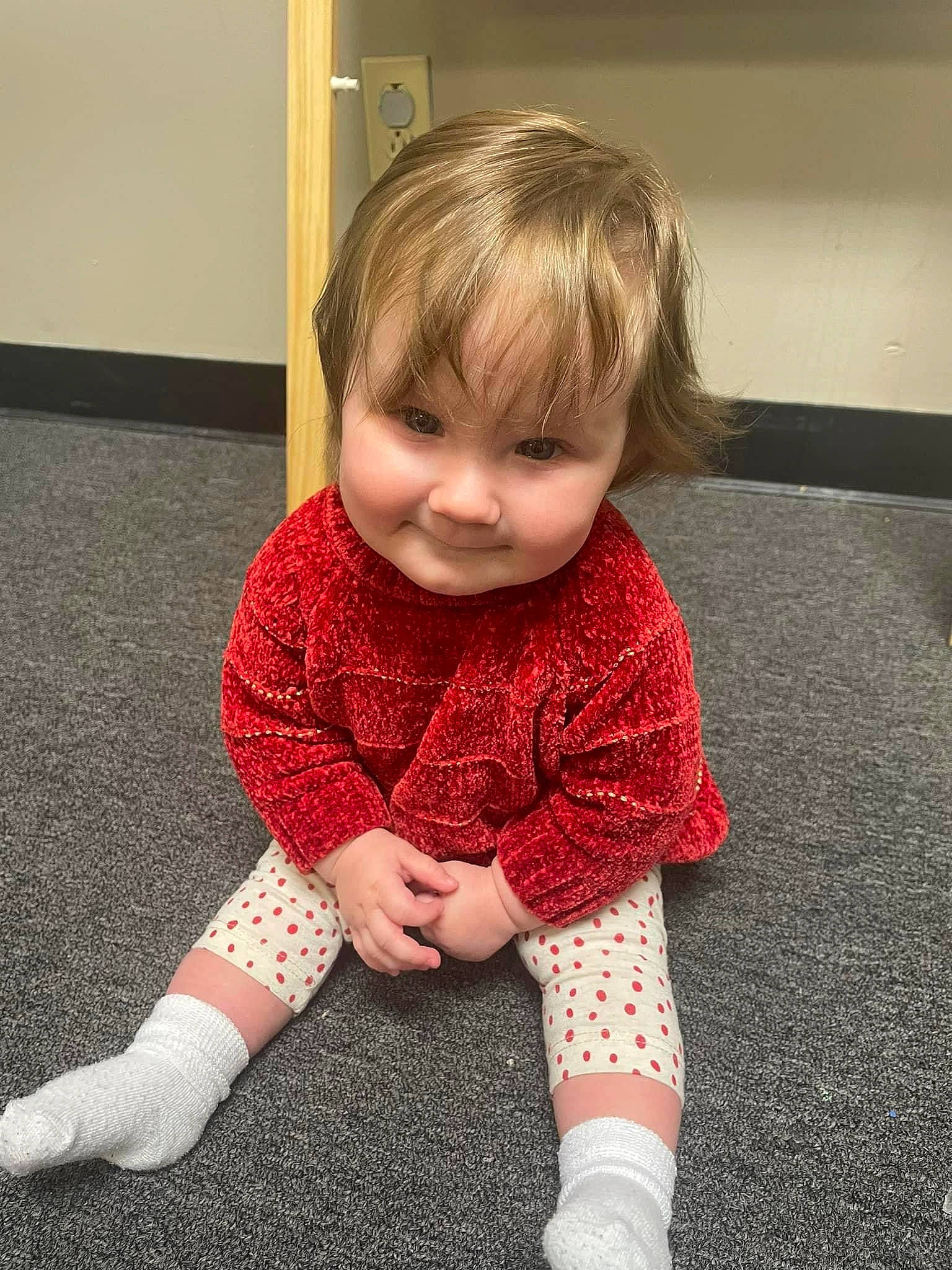 Angelina is registered to the contest to win money with this photo: baby, baby_toddler_clothing, child, dress, eye, face, finger, floor, flooring, human_body, human_leg, knee, leg, pattern, person, skin, sleeve, smile, sock, toddler