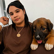 Sparky joined the competition — help win amazing prizes! woman, puppy, dog, pet, brown_shirt, white_watch, necklace, indoor, portrait, cute, tongue_out, relaxed, black_hair, earrings, face, paw, furniture, couch, casual, young_adult