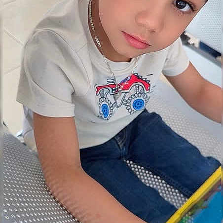 Xadiel Estévez joined the competition — help win amazing prizes! bench, boy, casual, casual_clothing, child, curious, expression, floor, furniture, indoor, jeans, looking_up, metal_bench, portrait, short_hair, sitting, tablet, technology, white_tshirt, young