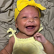 Bianca is registered to the contest to win money with this photo: baby, smiling, yellow_headband, yellow_outfit, infant, happy, lying_down, blanket, cute, child, portrait, skin, face, hand, headwear, fabric, closeup, indoors, newborn, cheerful