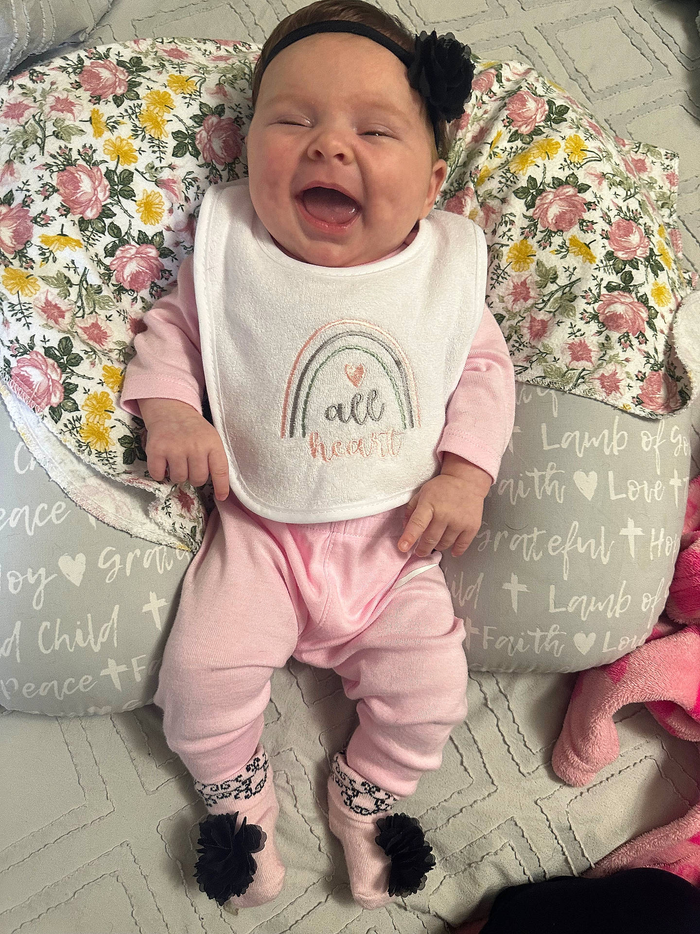 Meadow joined the competition — help win amazing prizes! baby, bib, child, comfort, cushion, cute, face, floral_pattern, happy, headband, home, indoor, infant, lying_down, person, pink_clothing, portrait, smiling, sock, soft_toys