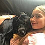 girl, dog, black_dog, smiling, couch, hugging, casual_clothing, bracelet, long_hair, indoor, pet, friendship, relaxed, portrait, face, young_person, comfort, animal, snuggling, natural_light