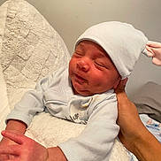 Myles Gray is registered to the contest to win money with this photo: newborn, baby, infant, hat, bunny_ears, hand, blanket, soft_texture, sleeping, peaceful, cute, clothing, person, indoor, resting, young_child, portrait, skin, headwear, cozy