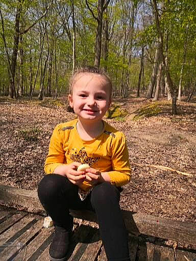 Maylan a rejoint le concours — aidez-le/la à gagner de superbes lots ! child, fawn, forest, fun, grass, happy, joy, leisure, natural_landscape, people_in_nature, person, plant, recreation, sitting, smile, soil, t_shirt, toddler, tree, wood