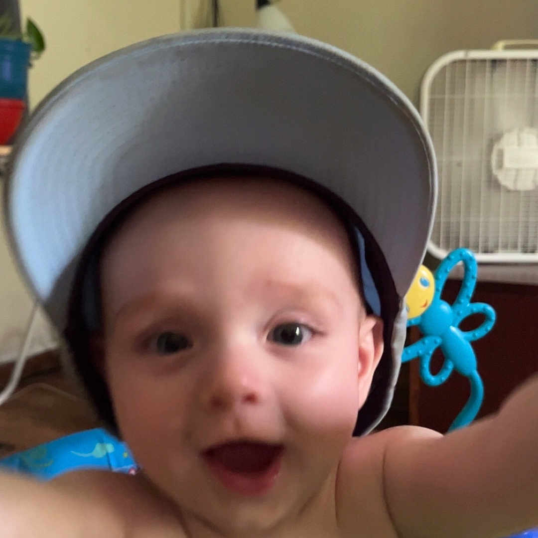Ryder is registered to the contest to win money with this photo: baby, baseballcap, bodypart, bonnet, cap, clothing, crib, face, finger, furniture, hand, happy, hat, head, indoors, infantbed, person, photography, portrait, sunhat
